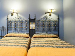 Patró卡萨萨斯特塞吉酒店的一间卧室配有两张床,墙上有两盏灯