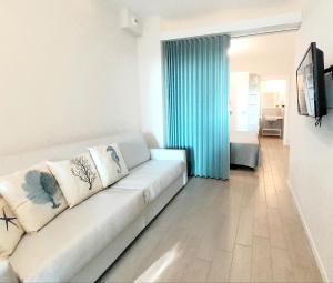 切塞纳蒂科阿里斯公寓的客厅配有白色沙发和蓝色窗帘