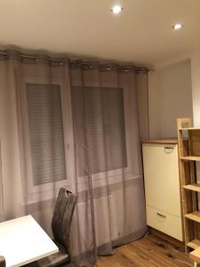 维也纳新城Nina Apartment的客房设有2扇带窗帘和架子的窗户。