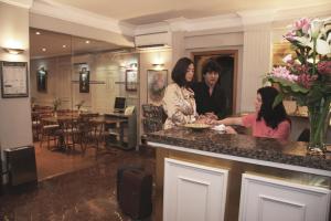 圣塞瓦斯蒂安巴伊亚旅馆的三名妇女在餐厅柜台站立