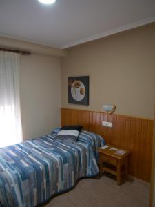托雷利亚诺Hostal Durá的一间卧室配有一张床和一张桌子