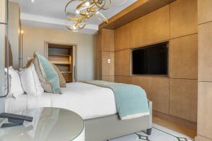 路易斯威尔欧姆妮卢森维尔酒店的一间卧室配有一张床、一张桌子和一台电视。