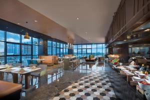萧山杭州空港假日酒店的餐厅设有桌椅和窗户。