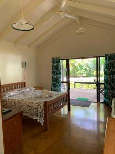 拉罗汤加库拉卡巴那斯别墅的一间卧室设有一张床和一个滑动玻璃门