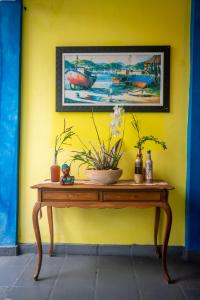 阿拉亚尔-杜卡布Pousada Salvatore的黄色墙顶上带鲜花的桌子