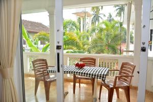尼甘布Yolanda Villa Negombo的门廊上的用餐室配有桌椅