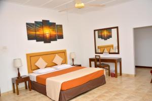 尼甘布Yolanda Villa Negombo的一间卧室配有一张床、一张桌子和一张四柱床。