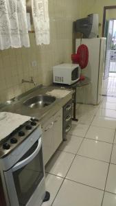巴尔内阿里东海滩ILHA DOS CORAIS -Ap 304 C的厨房配有水槽、炉灶和微波炉
