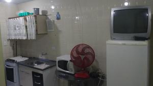 巴尔内阿里东海滩ILHA DOS CORAIS -Ap 304 C的带微波炉的小厨房和电视。