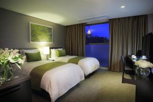釜山阿文特里釜山酒店的酒店客房设有两张床和窗户。