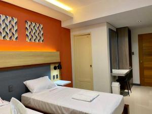 土格加劳Kara’s Pension House的一间卧室配有一张橙色墙壁的床