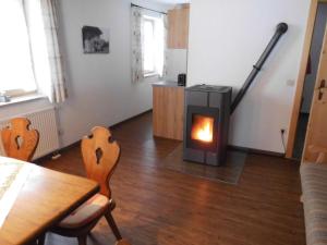 雷特温克尔Seewiesenalm的客厅设有壁炉、桌子和椅子