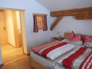 雷特温克尔Seewiesenalm的一间卧室配有红色和白色枕头的床