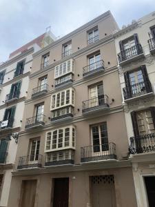 马拉加Pinar Malaga Rooms的大型白色建筑,设有窗户和阳台