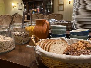 伍珀塔尔Haus Honigstal Landhaus Café的桌子上放着一篮面包和碗