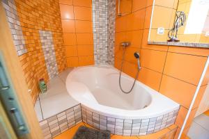 托尔明Apartments Ole的浴室设有浴缸,铺有橙色瓷砖。