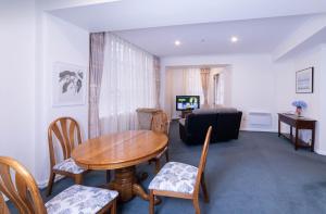 惠灵顿Wellington CBD Apartment的客厅配有桌椅和沙发