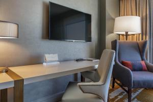 路易斯威尔欧姆妮卢森维尔酒店的配有书桌和电视的酒店客房