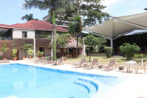 蒙罗维亚Mamba Point Hotel的一个带椅子的游泳池以及一座房子