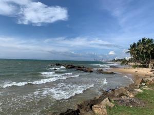 拉维尼亚山Colombo Beach Hostel的一片拥有岩石、海洋和棕榈树的海滩