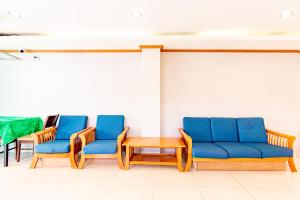 合艾Oun Residence的一间设有蓝色椅子和桌子的等候室