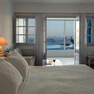 阿克罗蒂里麦森德斯莱斯豪华套房酒店的一间卧室配有一张床和一杯葡萄酒