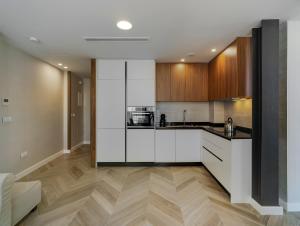 卡塔赫纳San Sebastian Suites的厨房配有白色橱柜和木地板。