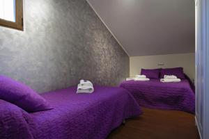 科卡LOS ALISOS的紫色床单的客房内的两张床