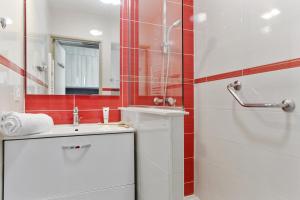 海滨布洛瑞Résidence Pierre & Vacances La Corniche d'or的浴室配有盥洗盆和带镜子的淋浴