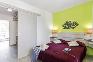 海滨布洛瑞Résidence Pierre & Vacances La Corniche d'or的一间卧室配有一张大床和紫色毯子