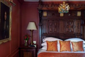 伦敦黑兹利特酒店的一间卧室配有一张大床和木制床头板