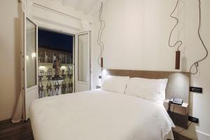 佛罗伦萨托纳伯尼景住宿加早餐旅馆的卧室设有一张白色大床和一扇窗户。