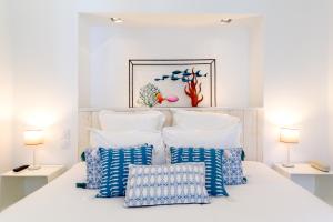 圣马丹德雷杰特酒店的白色卧室,床上配有蓝色和白色枕头