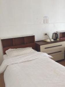 米卡萨拉Meekatharra Hotel的卧室配有白色的床和床头柜