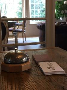 根特莱佩贝德酒店的桌子上放着书,桌子上放着电话