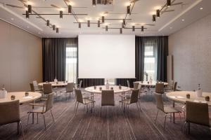 汉堡北城汉堡假日酒店 的一间会议室,配有桌椅和投影屏幕