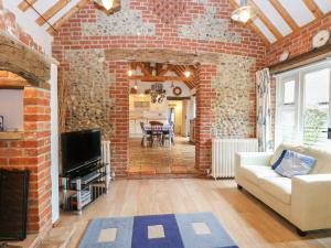 West BradenhamStable Cottage的一间带砖墙和沙发的客厅