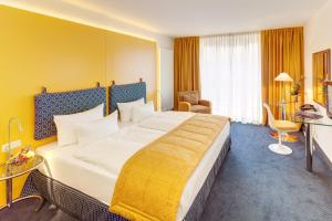 美因河畔法兰克福祖亚历山大酒店的酒店客房设有一张黄色墙壁的大床