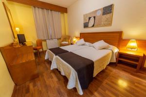 鲁比罗德莫拉Hotel de Montaña Rubielos的酒店客房设有一张大床和一台电视。