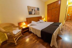 鲁比罗德莫拉Hotel de Montaña Rubielos的配有一张床和一把椅子的酒店客房