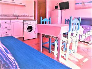 博罗尼亚Apartamentos Turisticos Trajano的厨房配有桌椅和洗衣机。