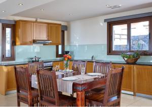 莫拉托斯Vasia Villas的厨房配有木桌、椅子和桌子。