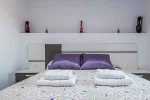 蒙特弗里奥Fantástica Casa de 3 BR y 3 Baños - Casa de Relax-的一间卧室配有一张带紫色和白色枕头的床