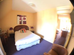 莫里亚克Auv'hôtel的一间卧室配有一张床和一张桌子及椅子