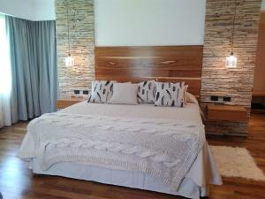 科隆Noha Casa de Campo的卧室配有一张白色大床和砖墙