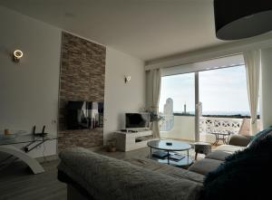 费拉古多Vila Gaivota 3G的带沙发和大窗户的客厅