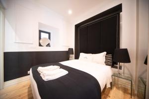 里斯本幸福里斯本公寓 - Bairro Alto的一间卧室配有黑色床头板和白色的床