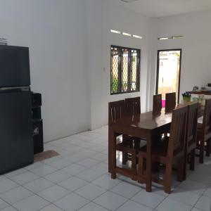 日惹内达勒姆迪阿约民宿的一间带桌椅和电视的用餐室