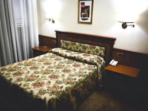阿韦利诺马拉加酒店的一间卧室配有一张带花卉床罩的床