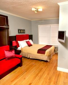 圣彼得堡庞塞德莱昂酒店的一间卧室配有一张床和一张红色椅子